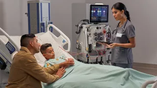 Healthcare professional with patient and family at hospital bedside
