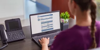 Woman on laptop viewing Sharesource remote patient management