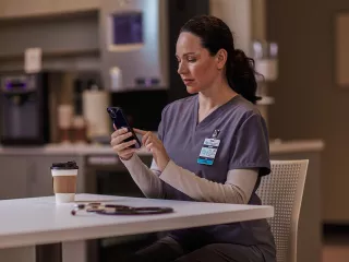 Healthcare professional sitting at table on phone