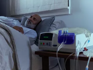 Man sleeping at home next to treatment machine