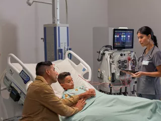 Healthcare professional with patient and family at hospital bedside