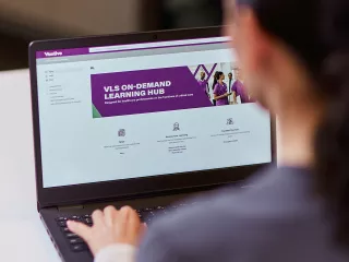 Healthcare professional looks at the Vantive Critical Care Academy website on their desktop computer