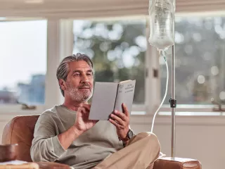 Man reading a book while receiving treatment