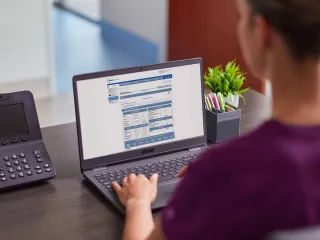 Woman on laptop viewing Sharesource remote patient management